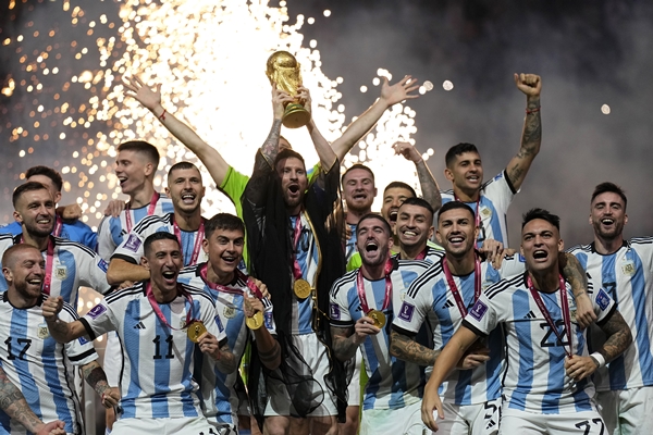 아르헨티나의 리오넬 메시가 18일(현지시간) 카타르 루사일 스타디움에서 열린 2022 카타르 월드컵 정상에올라 우승컵을 들고 동료들과 기념사진을 찍으며 환호하고 있다. /뉴시스