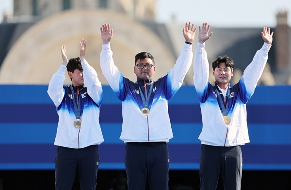 김우진(청주시청), 김제덕, 이우석이 29일(현지시각) 프랑스 파리 레쟁발리드에서 열린 파리올림픽 양궁 남자 단체전 시상식에서 금메달을 목에 걸고 두 팔을 들어 올리고 있다. /뉴시스